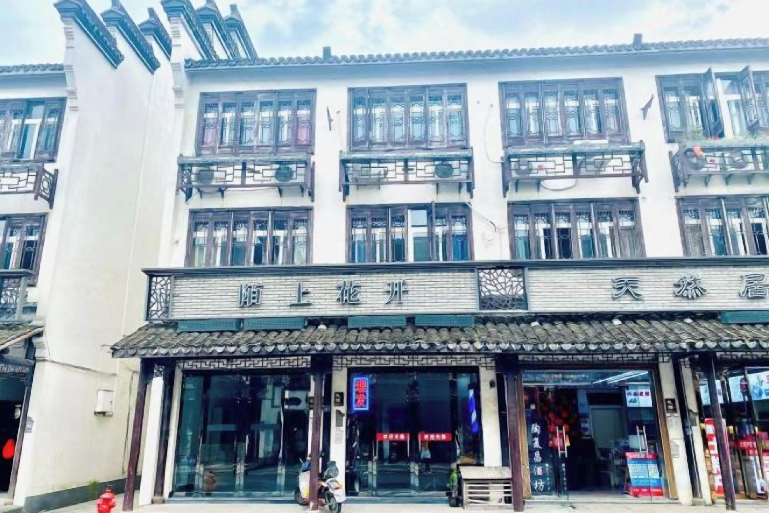 A traditional building with multiple floors, large windows, and a tiled roof.