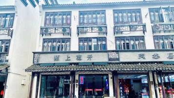 A traditional building with multiple floors, large windows, and a tiled roof.