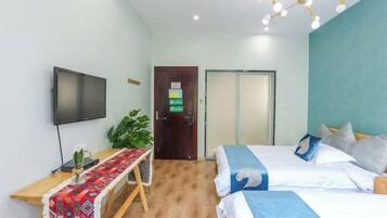 Habitación de hotel con cama, mesita de noche, televisor y una puerta con un letrero.