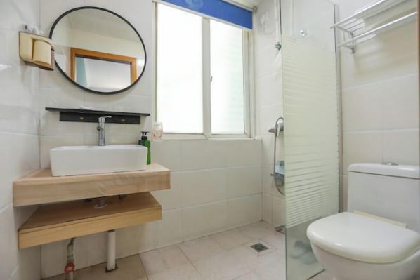 A bathroom with a white sink, mirror, and toilet. - Moshang Huakai Inn (Tongxiang)