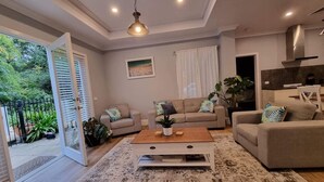 A modern living room with a sofa set, a coffee table, and a dining area. - 229 - The Pool House (South Albury)