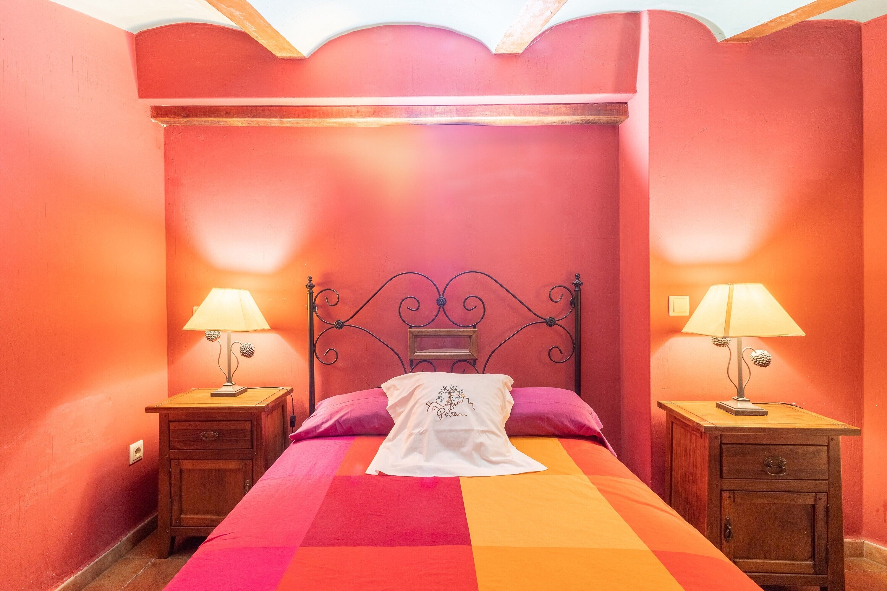 Een slaapkamer met een bed, twee nachtkastjes met lampen en een hoofdbord.