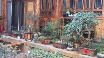 Un edificio de madera tradicional con numerosas plantas en macetas y un alféizar de piedra.