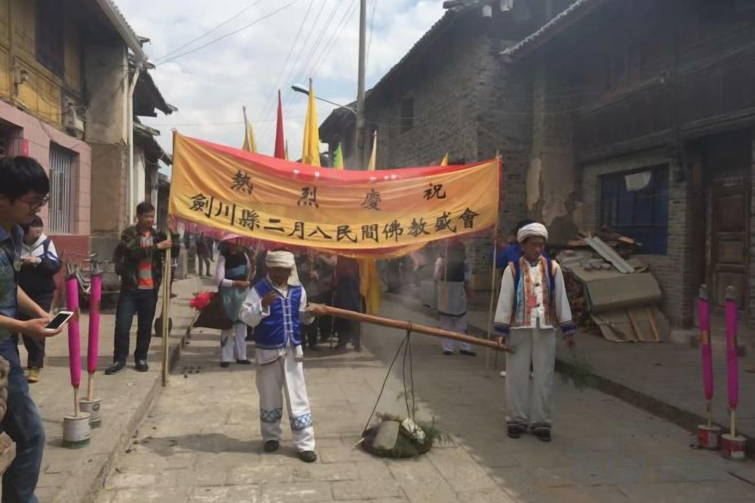 A street scene with a yellow banner, people, and traditional Chinese architecture.