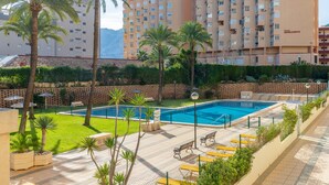 A hotel with a swimming pool, palm trees, and a view of mountains. - Apartment 'Calp Place Wifi Fibra' with Sea View, Wi-Fi and Air Conditioning (Calpe)