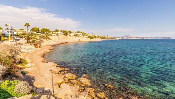 A coastal area with clear water, rocky shore, and buildings on a hillside. - Apartment 'Calp Place Wifi Fibra' with Sea View, Wi-Fi and Air Conditioning (Calpe)