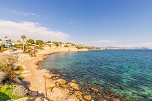 A coastal area with clear water, rocky shore, and buildings on a hillside. - Apartment 'Calp Place Wifi Fibra' with Sea View, Wi-Fi and Air Conditioning (Calpe)