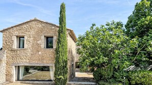 A stone building with a large window and a narrow entrance. - Villa Montagne by Interhome (Oppede)