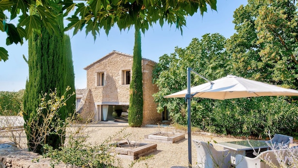 A stone house with a patio area, outdoor furniture, and a large umbrella. - Villa Montagne by Interhome (Oppede)