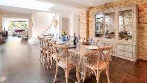 A dining area with a long table, chairs, and a glass cabinet. - Villa Montagne by Interhome (Oppede)