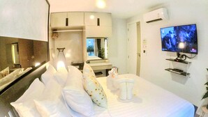 Ein Hotelzimmer mit Bett, Fernseher, Klimaanlage und Spiegel.