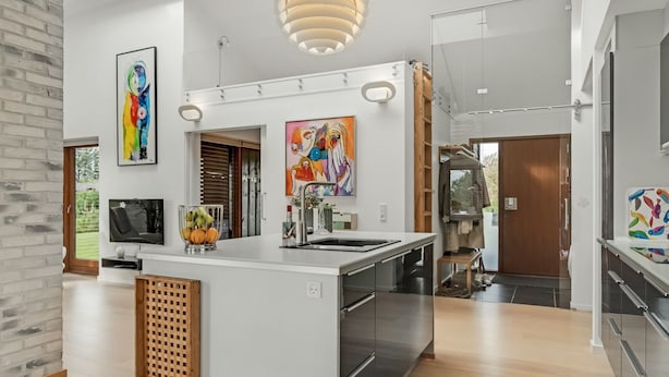 Una cocina moderna con una isla central, electrodomésticos de acero inoxidable y un ventanal grande.