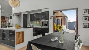 Una cocina moderna con armarios negros, una isla central y un comedor con mantel negro.