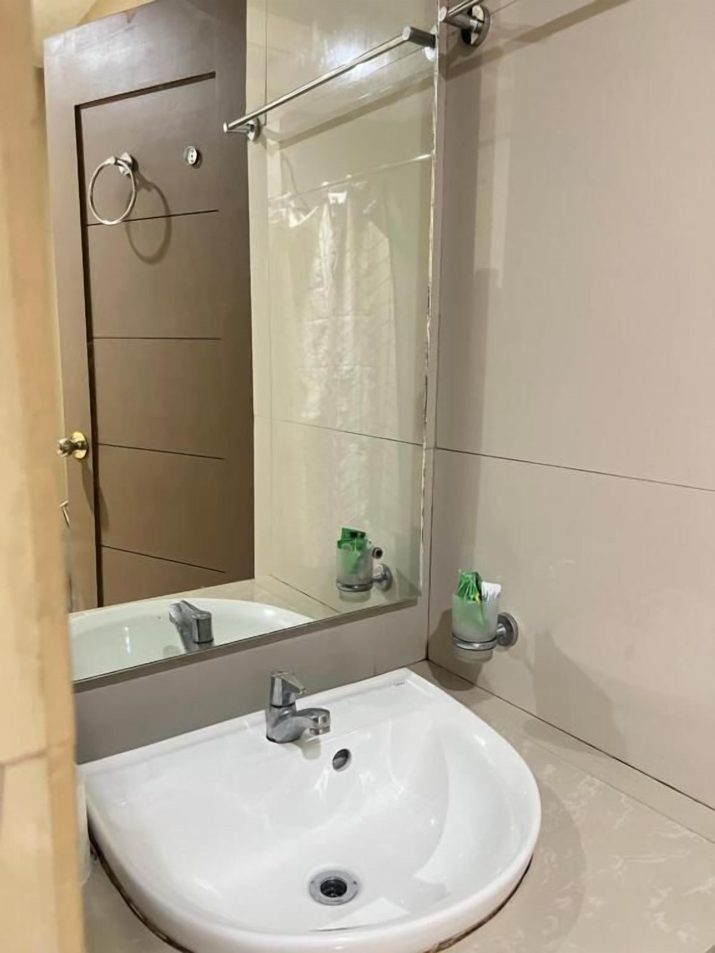 A bathroom with a white sink, a mirror, and a towel rack.