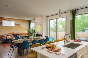 Una cocina moderna con una isla grande, comedor y una sala de estar acogedora.
