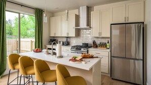 A modern kitchen with a central island, stainless steel appliances, and a view of the outdoors. - Hot Tub | Rooftop | Game Room | 5 Bathrooms (Denver)