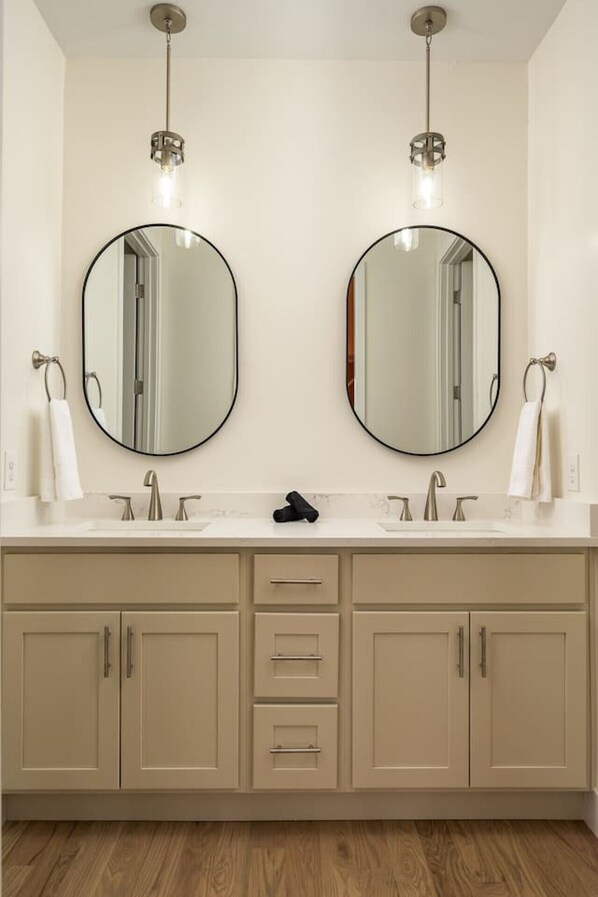 Une salle de bain avec deux lavabos, deux miroirs et un porte-serviettes.