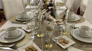A formal dining table set with white plates, gold-rimmed glasses, and a centerpiece with candles and flowers. - The Beautiful Views II (Noalejo)