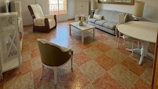 A spacious living room with a sofa, armchair, and a dining table. - The Beautiful Views II (Noalejo)