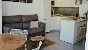 A modern kitchen with white cabinets, a built-in oven, and a microwave. - Atenea House (Caldes de Malavella)