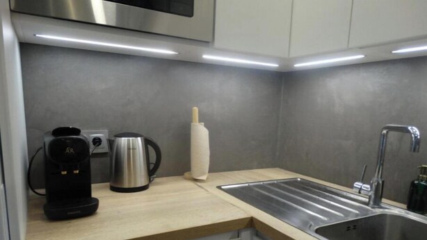 A modern kitchen with a stainless steel sink, a coffee maker, and a kettle on the countertop. - Atenea House (Caldes de Malavella)