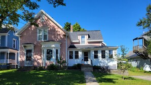 A two-story house with a front porch, a small front yard, and a driveway leading to the entrance. - Pretty Old House in Newport (Newport)