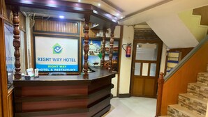 A reception desk with a sign for the Right Way Hotel & Restaurant. - Rightway Hotel & Restaurant (Kathmandu)