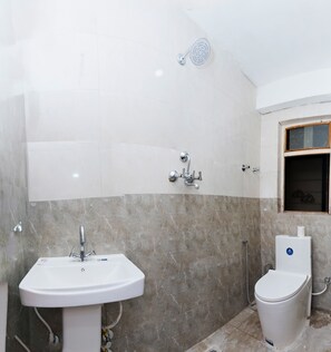 Un baño con lavamanos blanco, inodoro y ducha.