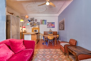 A cozy living room with a red sofa, a wooden dining table with chairs, a ceiling fan, and various wall art. - Agde Heritage, No. 16 (Agde)