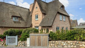 A traditional brick house with thatched roofs and a stone wall. - Part of the house with 5 rooms on the ground floor, basement, upper floor approx. 200 m² usable area (Wenningstedt-Braderup (Sylt))