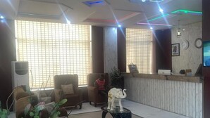 A lobby with a reception desk, seating area, and decorative elements like a small elephant statue. - De Bay Lux Hotel and suits (Lekki)