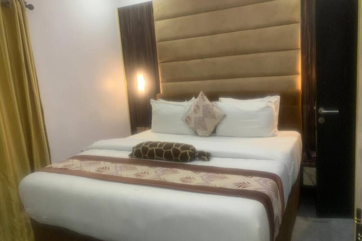 A neatly made bed with a patterned bedspread and a decorative pillow.