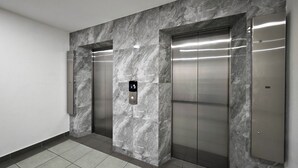 Ein moderner Aufzug mit Marmorwand und digitalem Display.