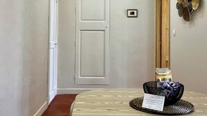 Een hal met een ronde tafel, een deur en een decoratief object aan de muur.