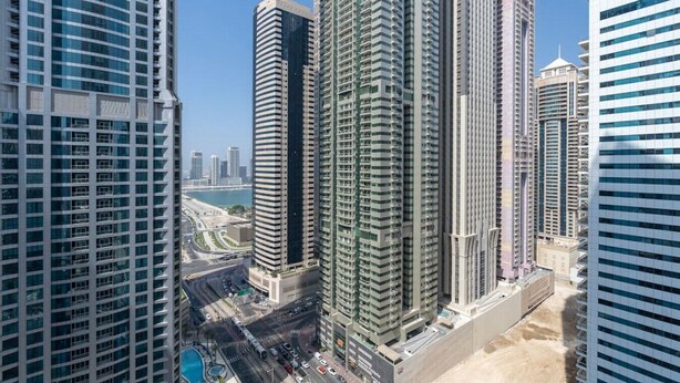 Un immeuble de grande hauteur doté d’une architecture moderne, comprenant de nombreux étages et une tour centrale imposante.