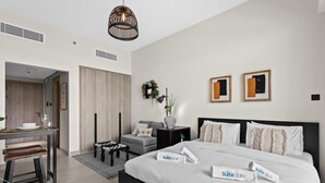Una habitación de hotel moderna con una cama grande, un escritorio y una zona de estar.
