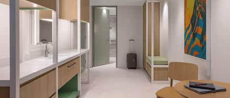 Una habitación de hotel moderna con baño, comedor y cama.