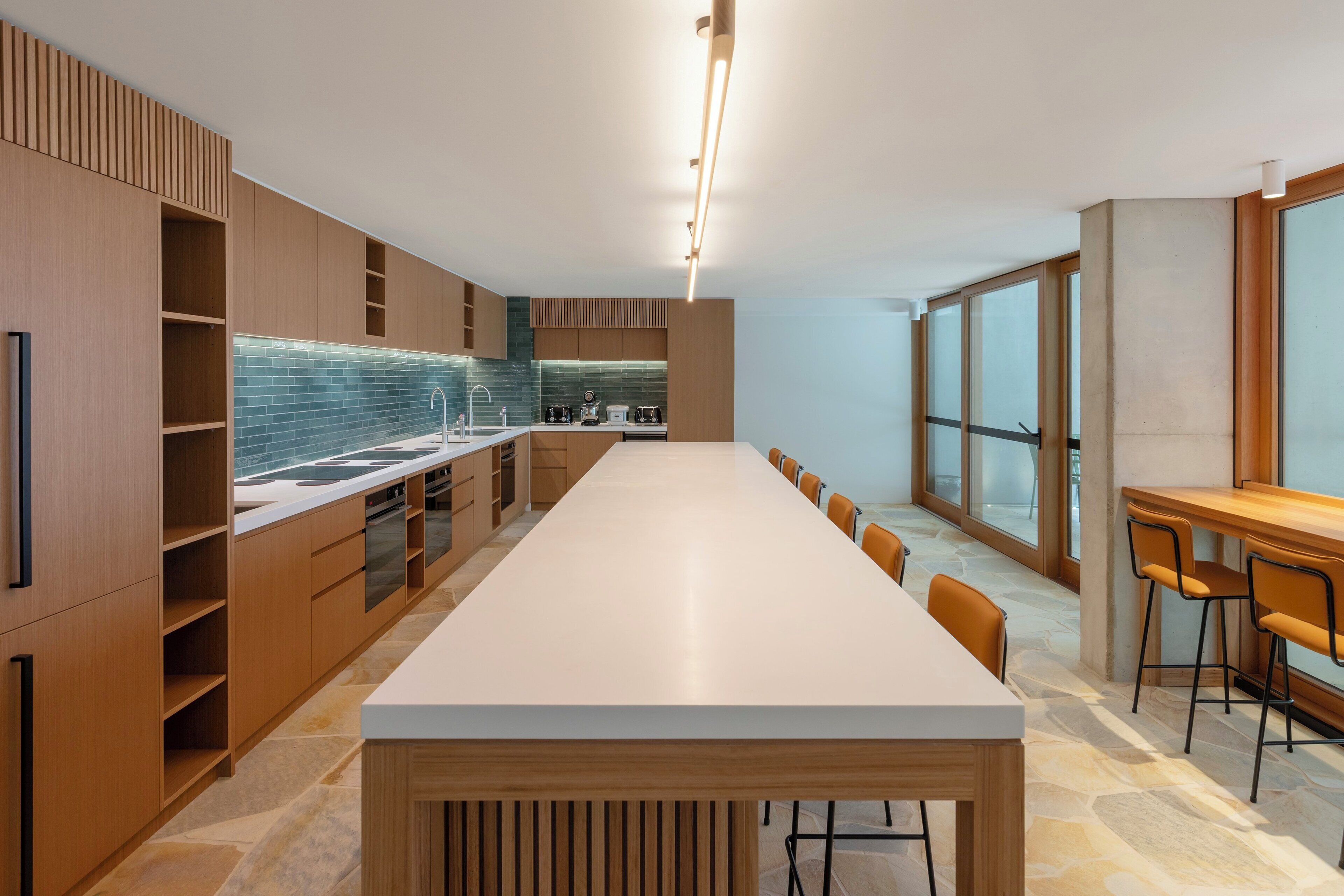 Una cocina moderna con una encimera amplia, armarios empotrados y un ventanal que aporta luz natural.
