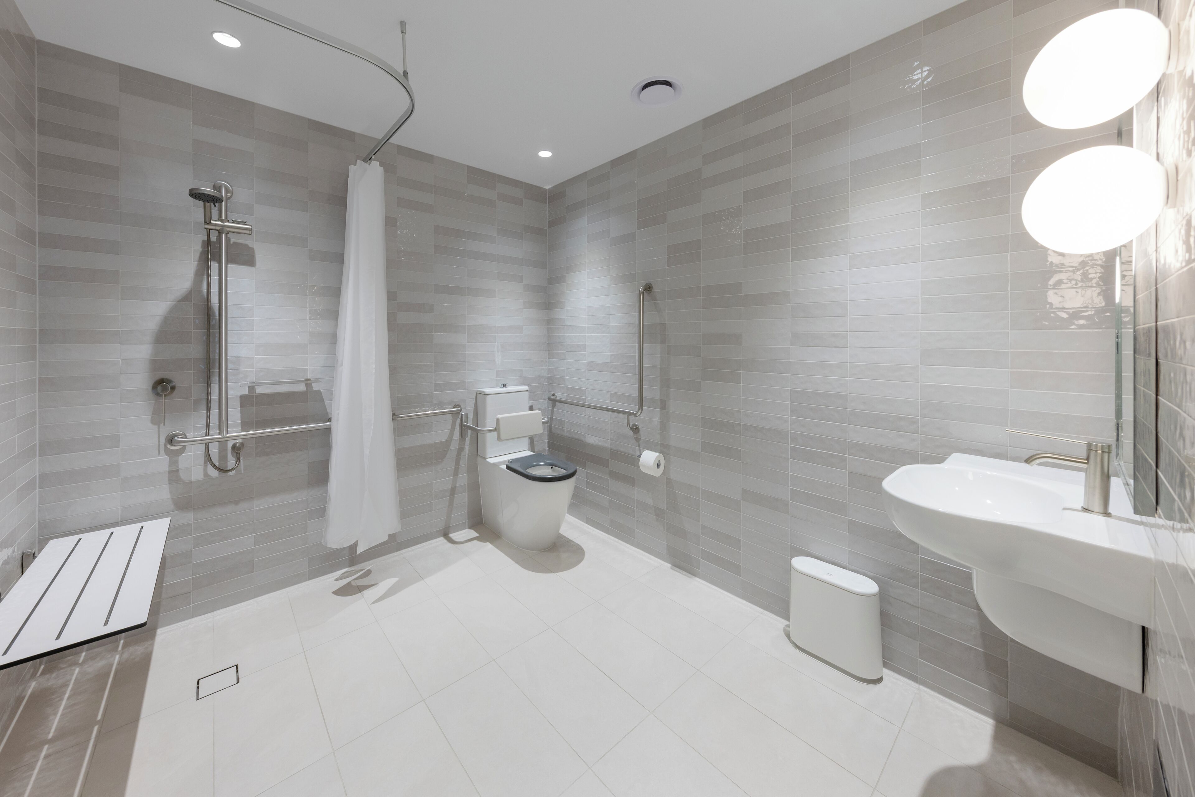 Un baño moderno con ducha, inodoro y lavamanos.
