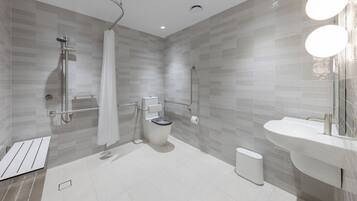 A modern bathroom with a shower, toilet, and sink.