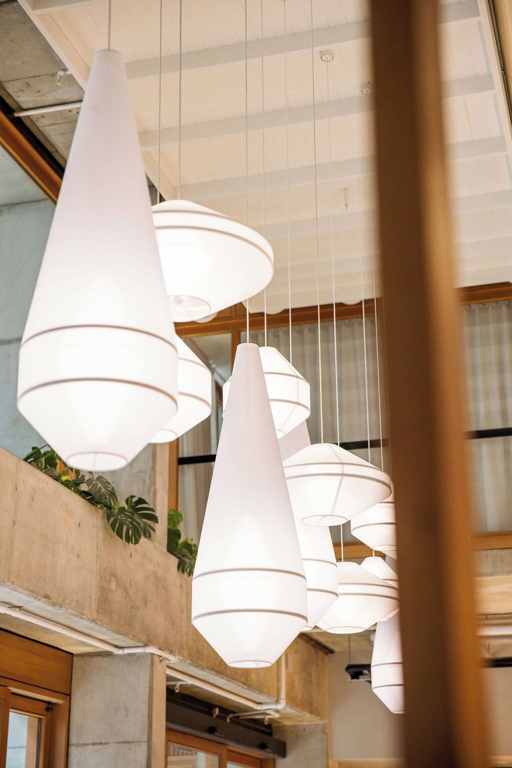 A modern interior with multiple white pendant lights hanging from the ceiling.
