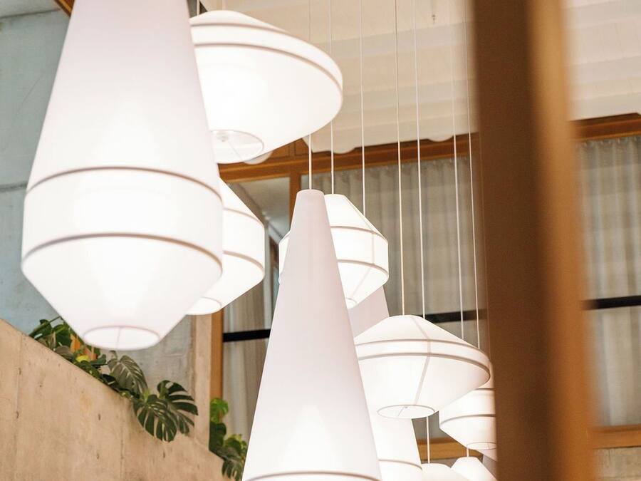 A modern interior with multiple white pendant lights hanging from the ceiling.