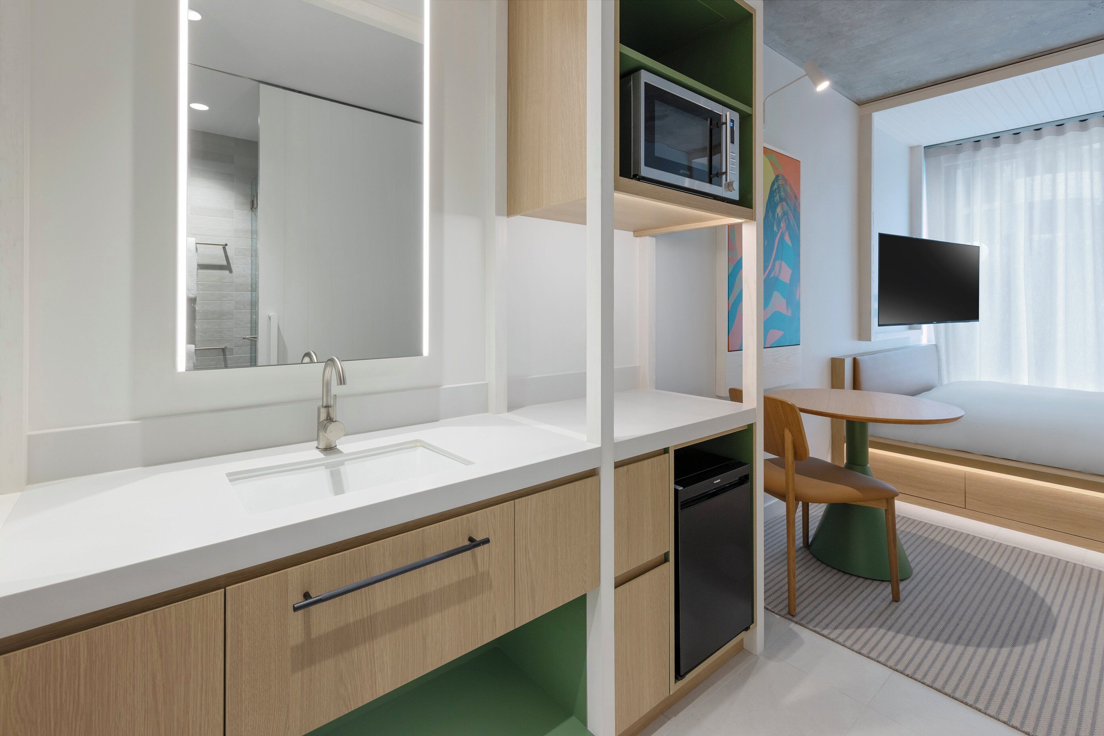 Een moderne badkamer met een grote spiegel, een wastafel en een ingebouwde vaatwasser.