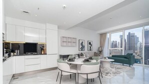 A modern living room with a dining area, a sofa, and a city view.