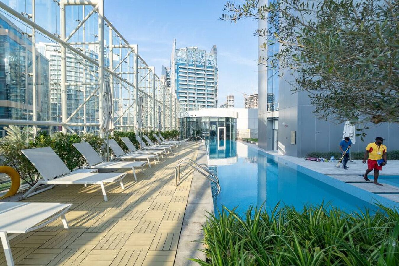Un espace piscine aménagé sur le toit, avec des chaises longues et une piscine.