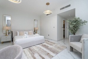 Un dormitorio moderno con una cama grande, mesitas de noche, un espejo y una planta en maceta.
