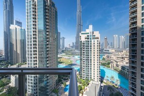 A high-rise building with a view of a swimming pool and surrounding urban landscape.