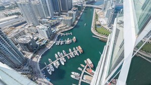 A high-rise building with a marina and boats.