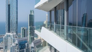 A high-rise building with a modern glass facade, overlooking a cityscape with various other high-rise buildings.