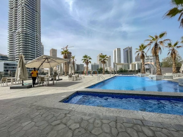 A rooftop pool area with a clear view of surrounding high-rise buildings and palm trees.